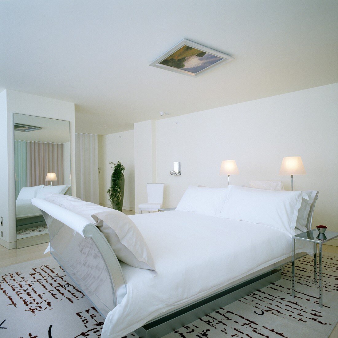 Room in elegant London hotel; rug with pattern of hand-writing, designer sleigh bed and framed picture on ceiling