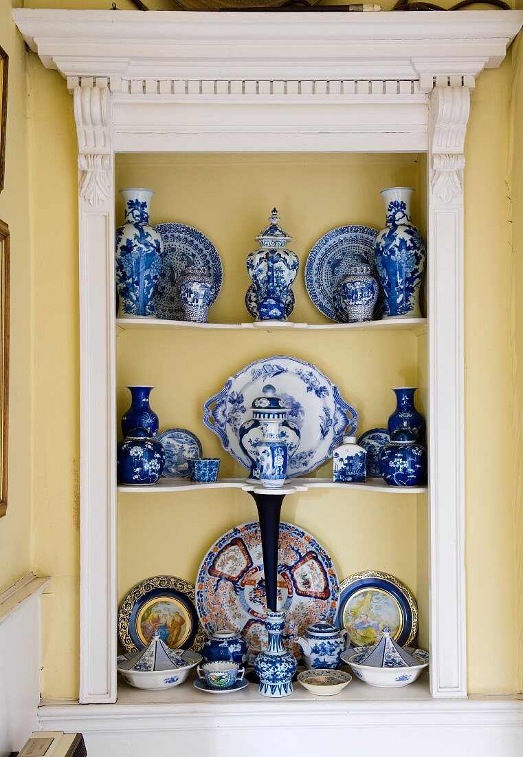 Sammlung wertvollen, chinesischen Porzellans in Einbauregal mit Holzumrahmung im klassizistischen Stil