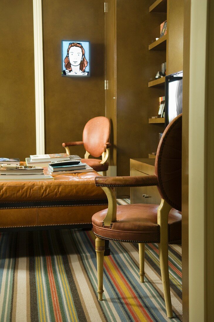 Leder-Couchtisch und Stühle, gestreifter Teppichboden und Einbauschrank in einem Wohnzimmer