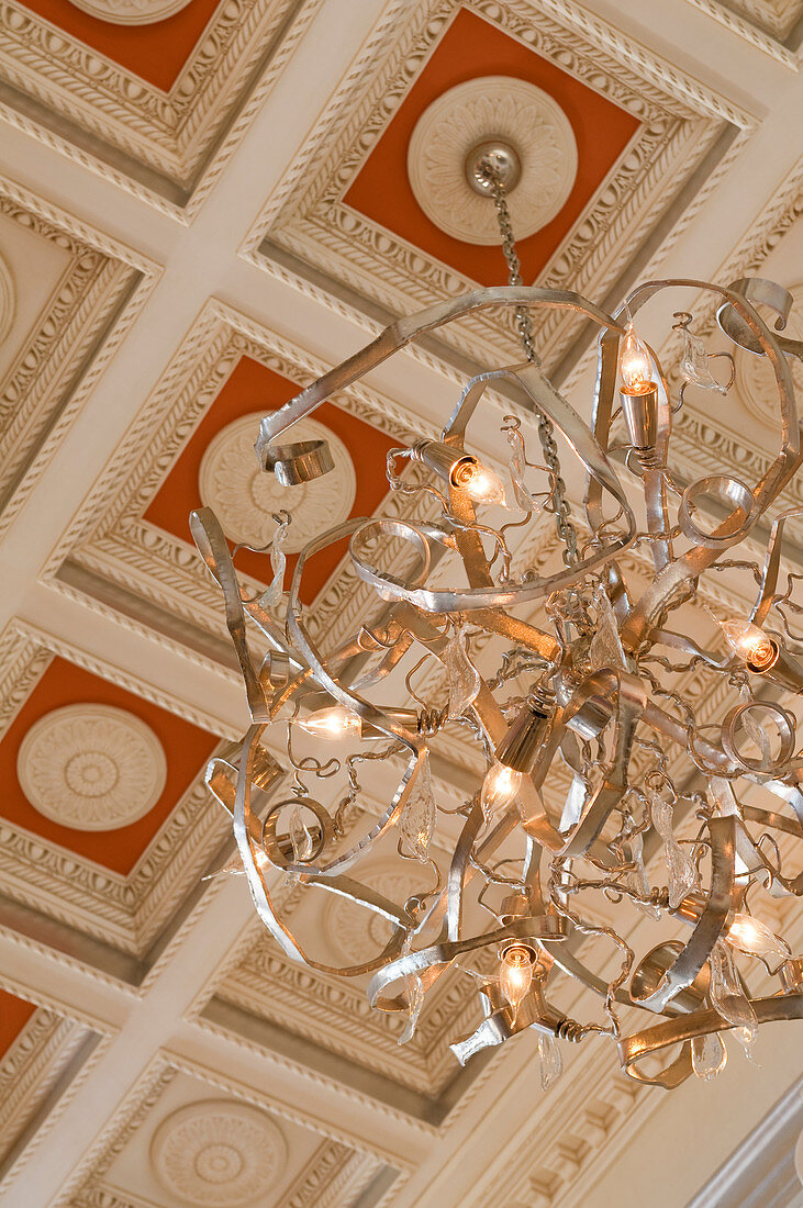 Modern chandelier hanging from coffered ceiling