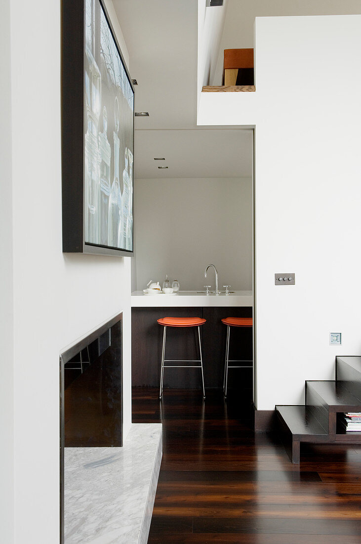 Blick vom Designer-Wohnzimmer auf die Küchentheke mit Barhockern