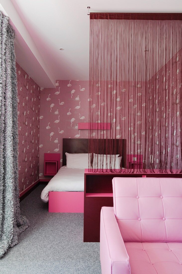 Zeitgenössisches Schlafzimmer mit rosa und grauen Farbtönen - Fadenvorhang als transparenter Raumteiler vor Doppelbett