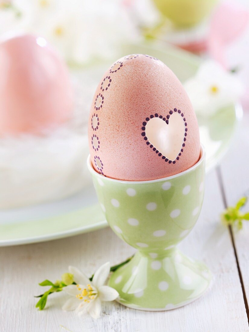 Easter egg decorated with heart in eggcup