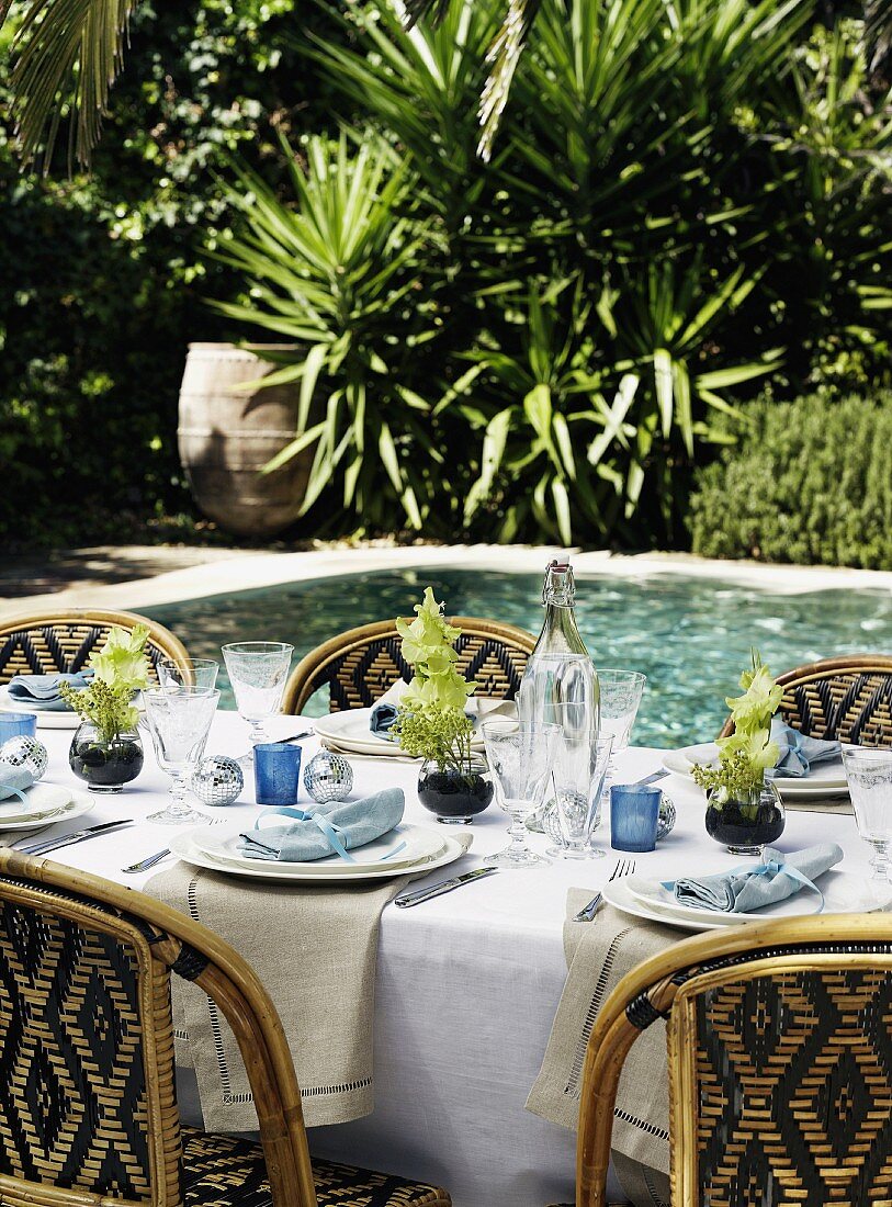 A festively laid table by a pool