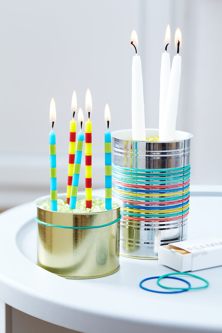 Originelle Kerzenhalter aus Blechdosen und bunten Gummibändern