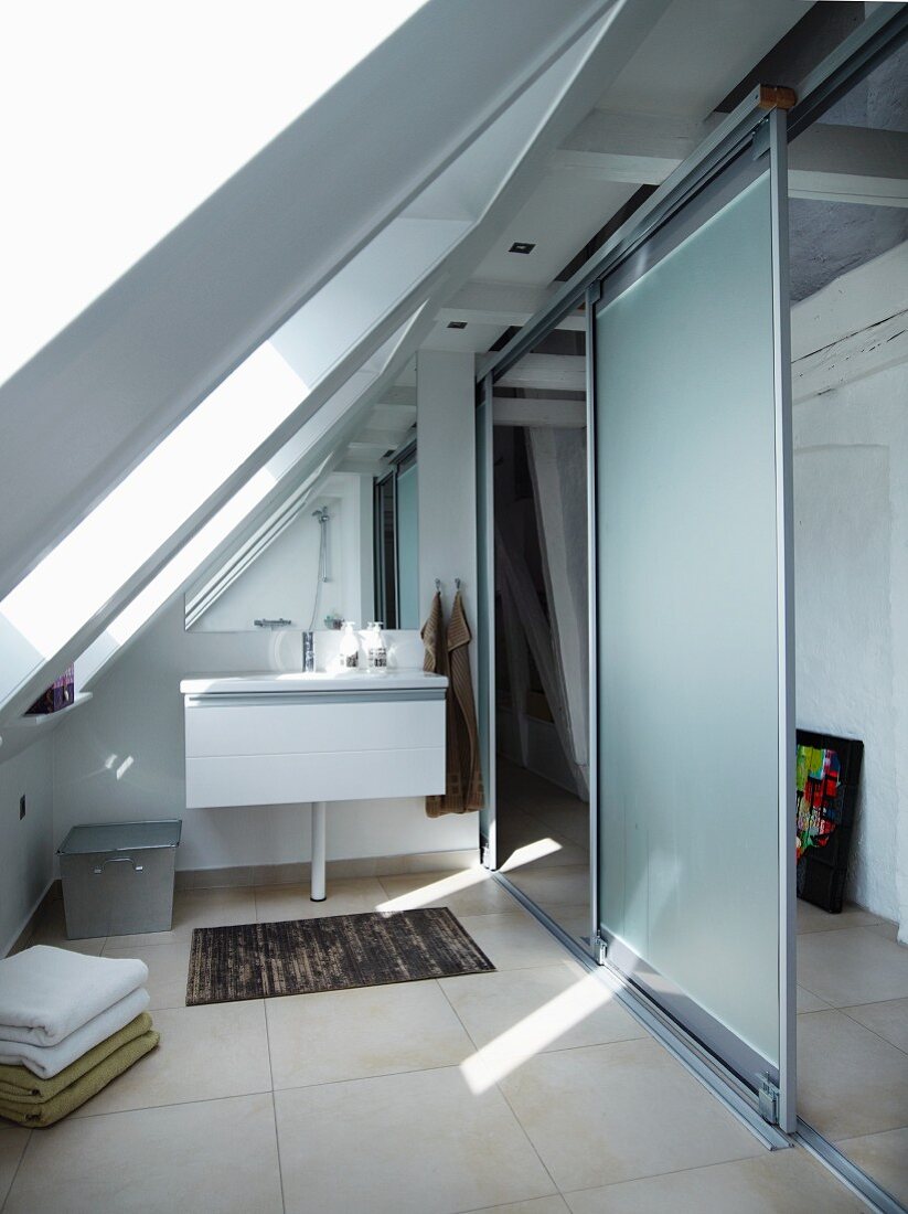 Modernes Bad mit Waschtisch und Abtrennung mit leichter Schiebeelementkonstruktion in ausgebautem Dach