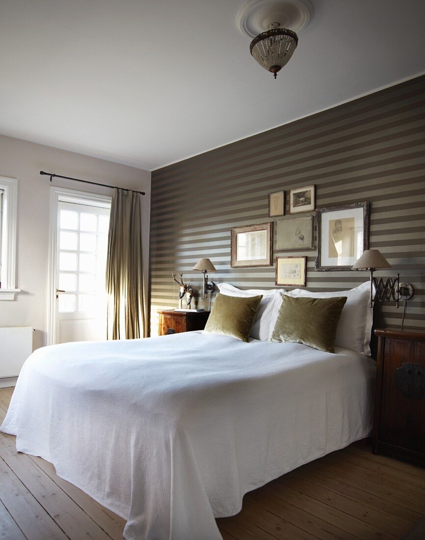 Elegant bedroom - bed with white throw against striped wallpaper