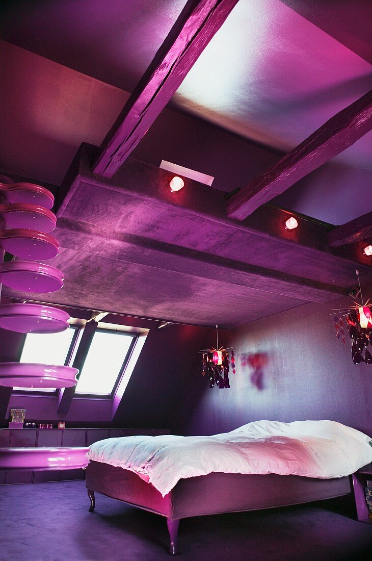 Moderner Schlafraum unter dem Dach mit flippiger Beleuchtung in Pink