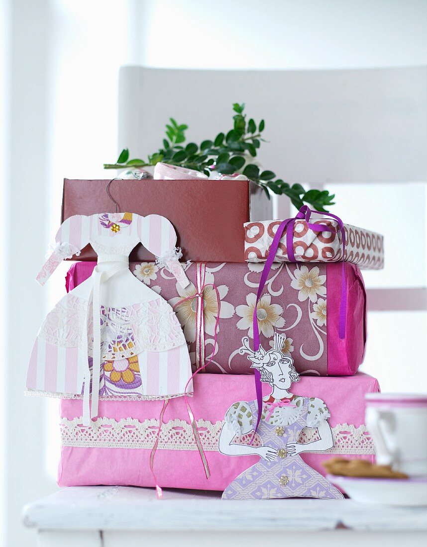 Verpackte Geschenke mit Papierdeko behängt