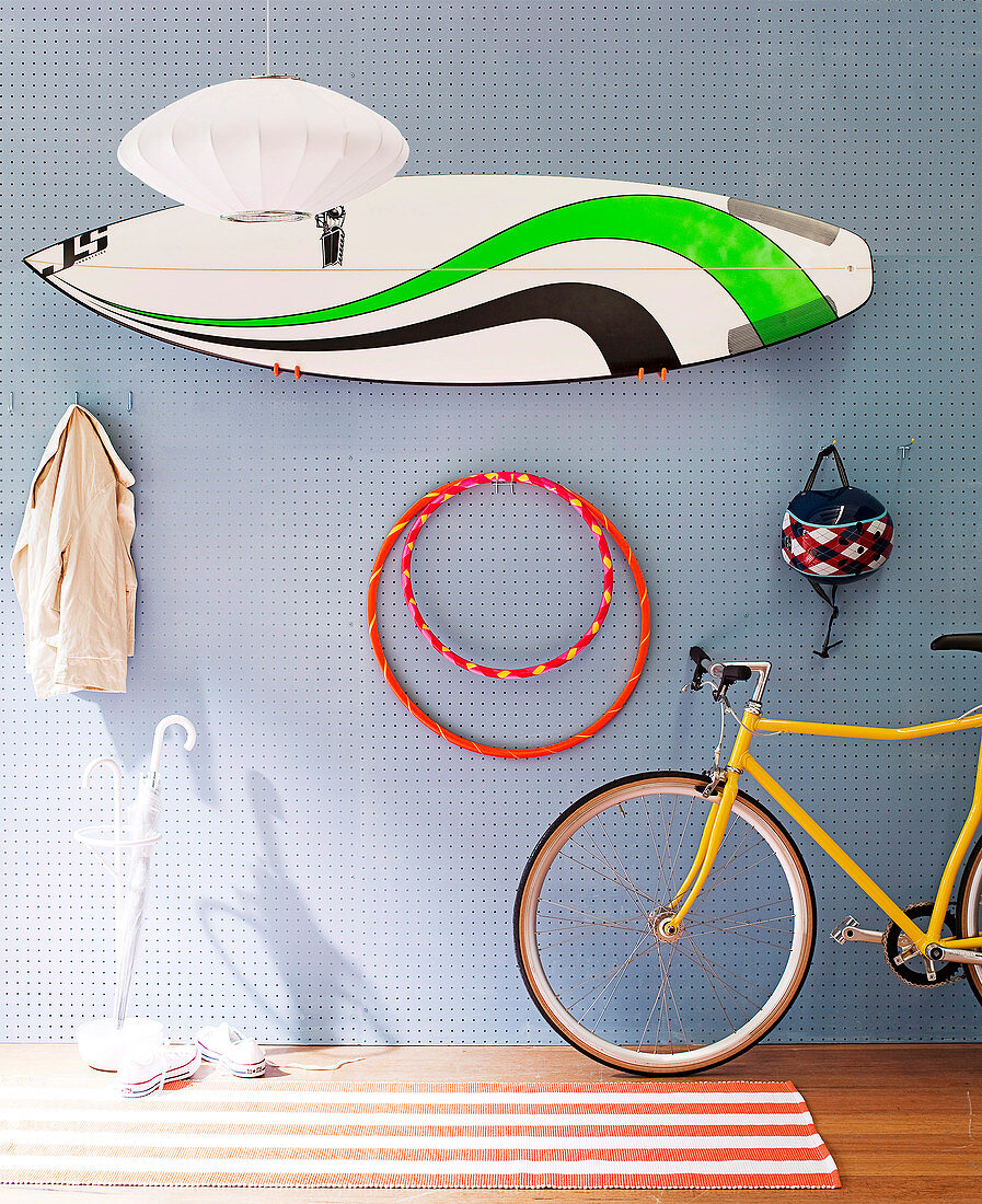 Sporting equipment hanging on perforated wall panel in teenager's bedroom