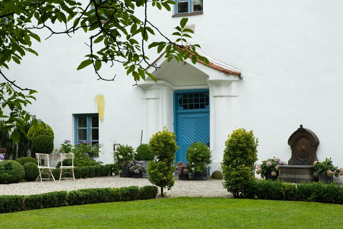 Blick auf weiße Hausfassade mit blauer Eingangstür
