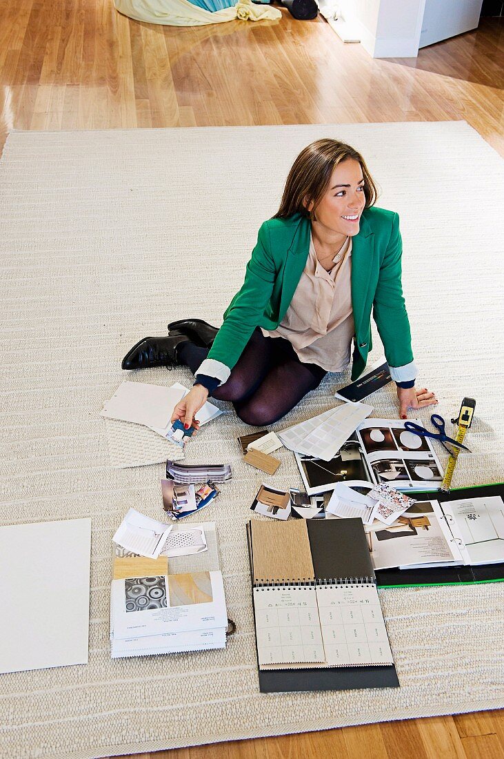 Woman on rug with pattern books for apartment renovation