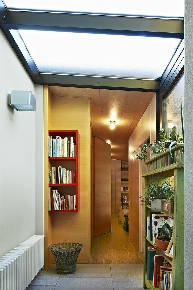 Foyer with frosted glass ceiling and view into hallway with warm artificial lighting