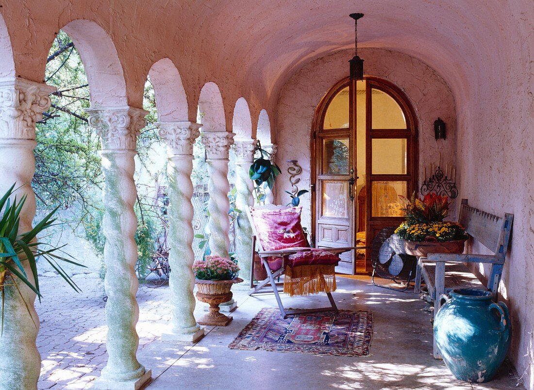 Antike Sitzmöbel und Vasen in rosa Arkadengang mit Rundbogen-Flügeltür