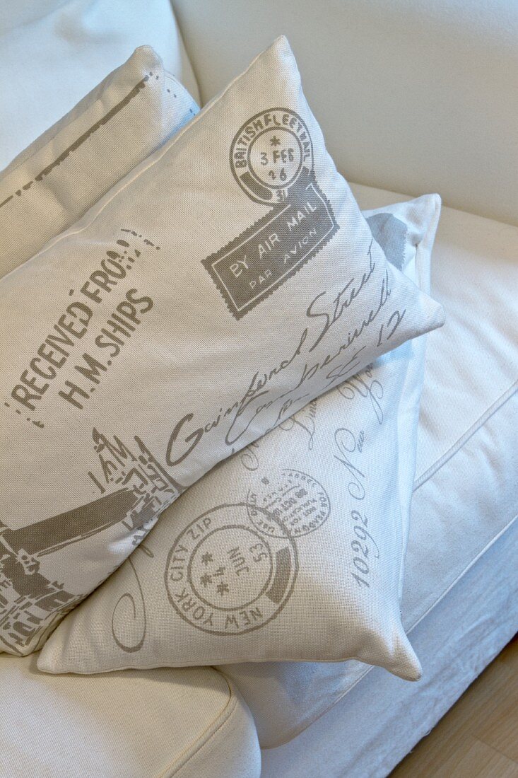 Cushions with lettering on covers on white sofa