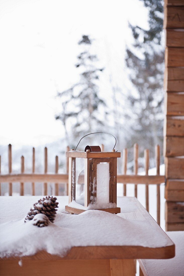 Lantern on snowy terrace table
