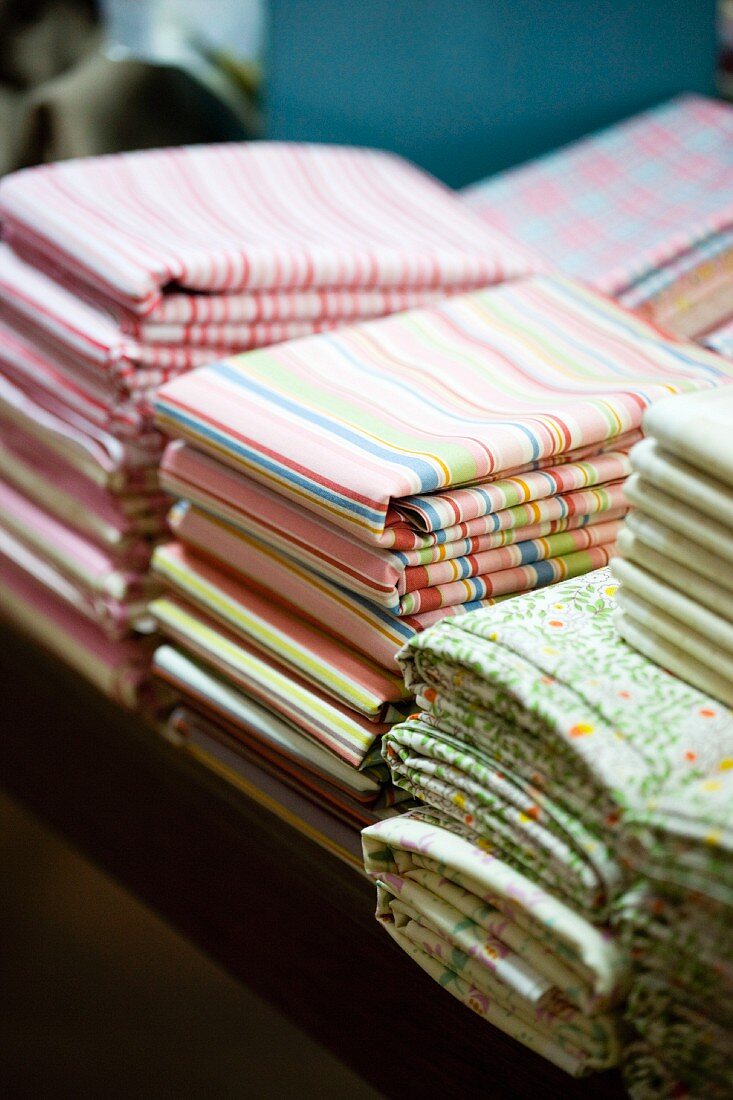 Striped and floral fabrics stacked on table