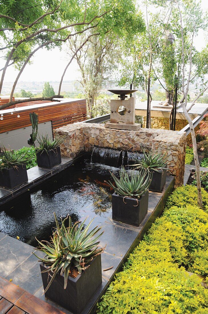 Large stone flags surrounding pond provide room for potted plants