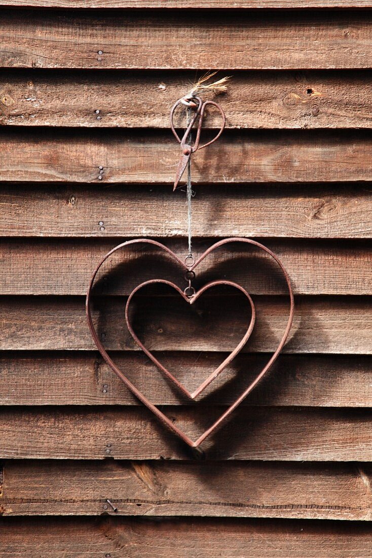 A decorative heart hanging on a wooden wall