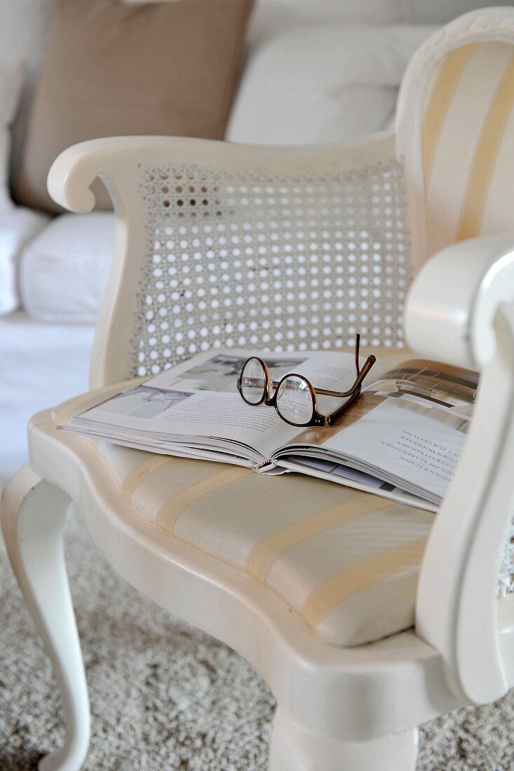 Relax with a book - white-painted chair with cushioned seat and curved frame