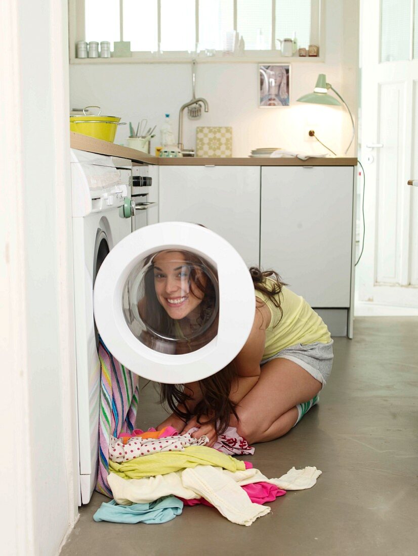Eine Frau füllt die Waschmaschine