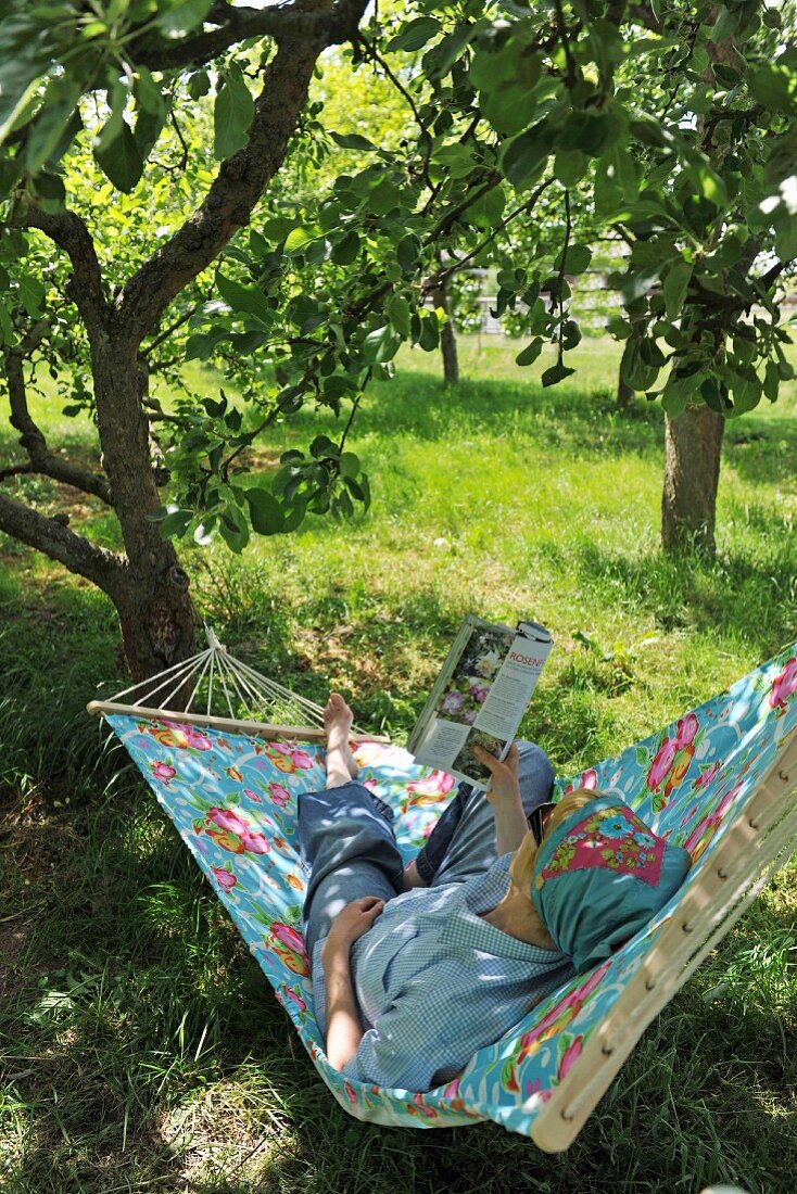 Schattiges Gartenplätzchen - Frau lesend in Hängematte