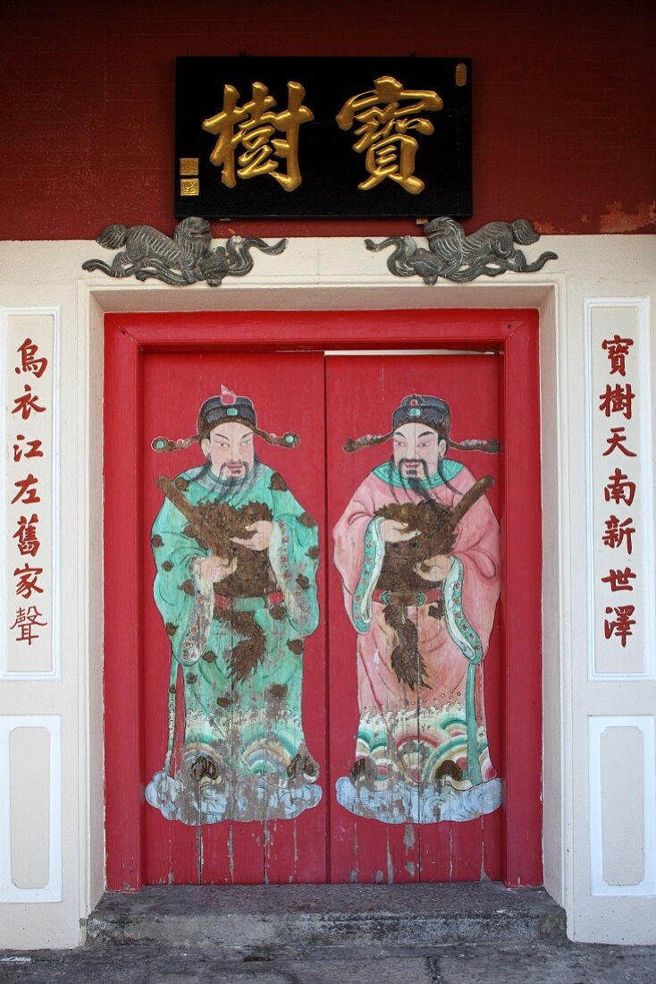 Rotes Haustor bemalt mit Figurenmotiven und asiatischen Schriftzeichen