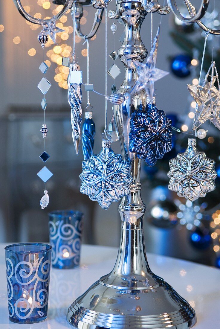 Silberner Kerzenständer mit Weihnachtsdeko behängt