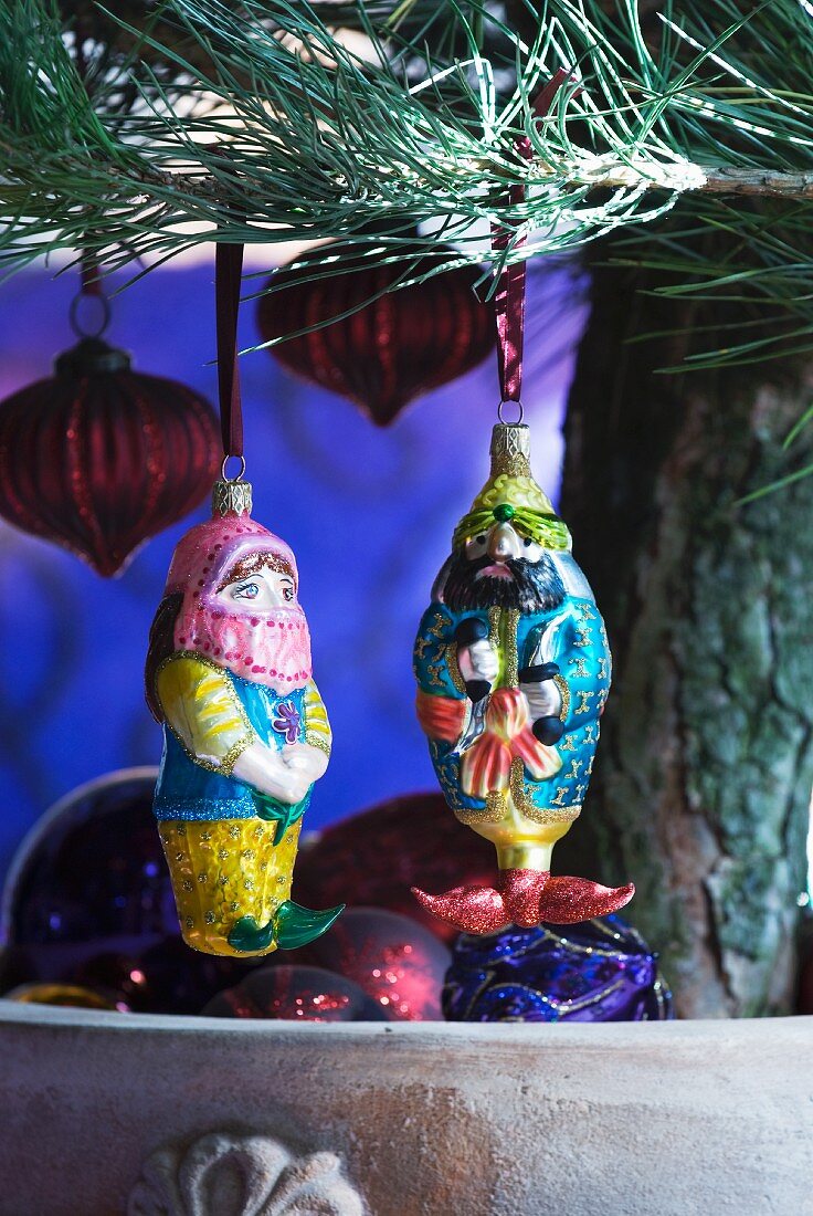 Baubles shaped like Oriental figures and lanterns hanging on Christmas tree