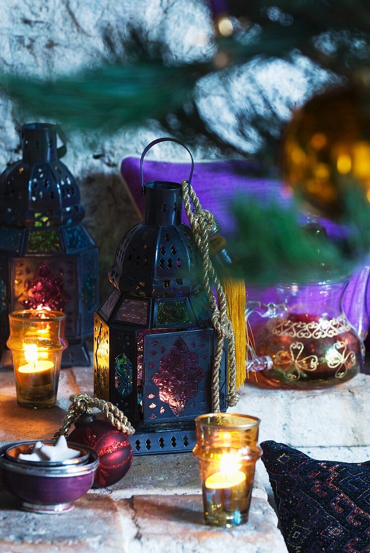 Oriental Christmas tabletop arrangement of lanterns and tealight holders of coloured glass