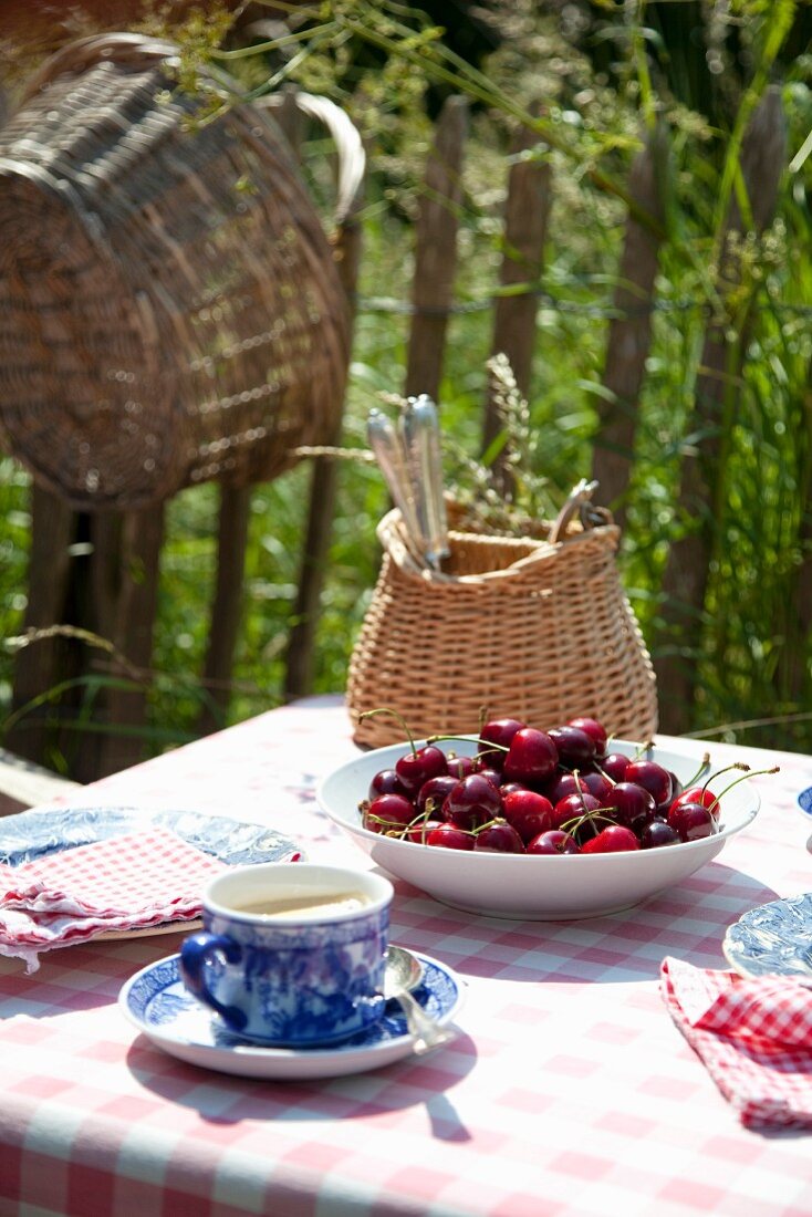 Garden table set with coffee and fresh cherries