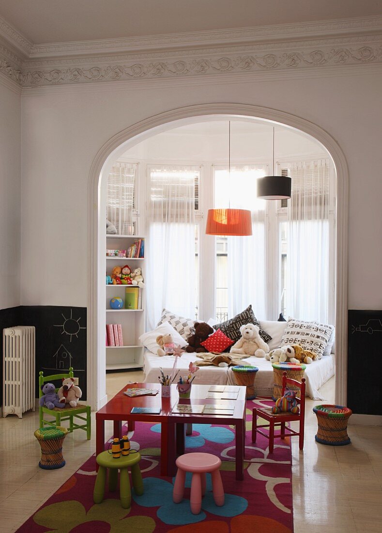 Colourful children's table and chairs in playroom with open doorway leading to child's bedroom