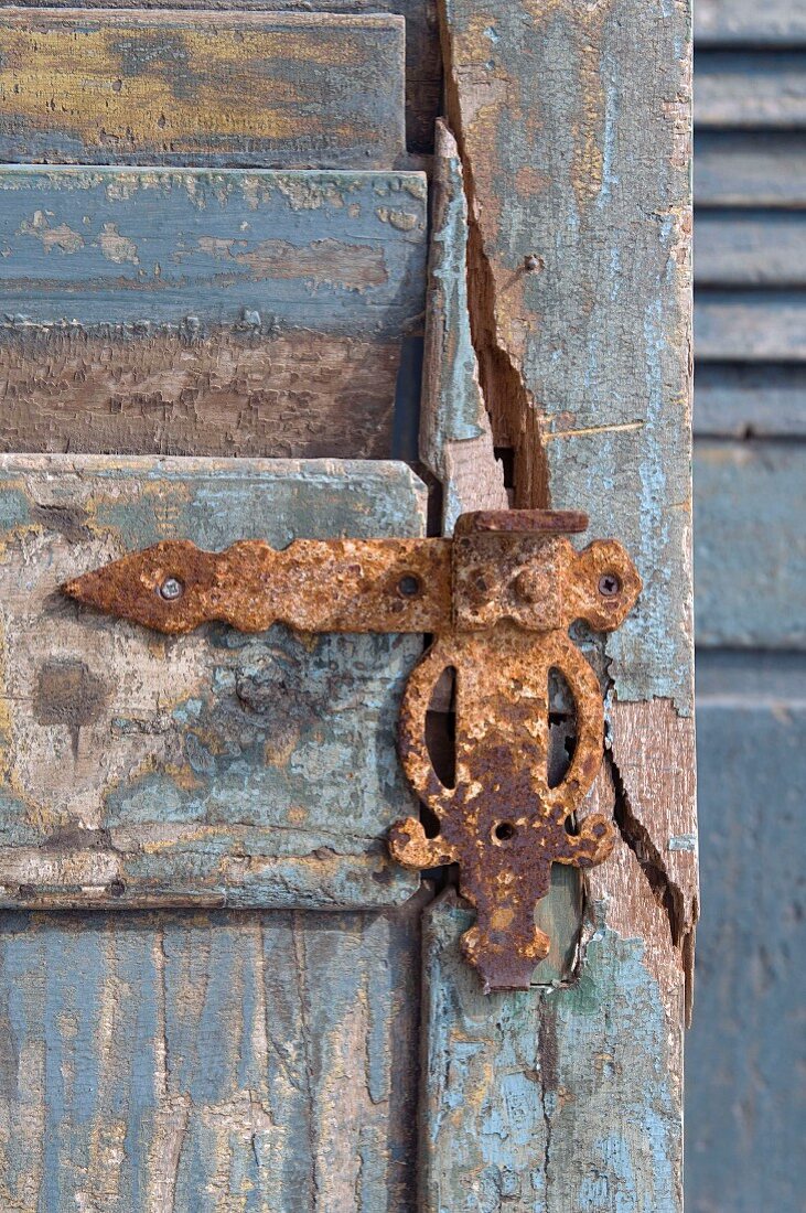 Rusty metal fitting on weathered wooden door