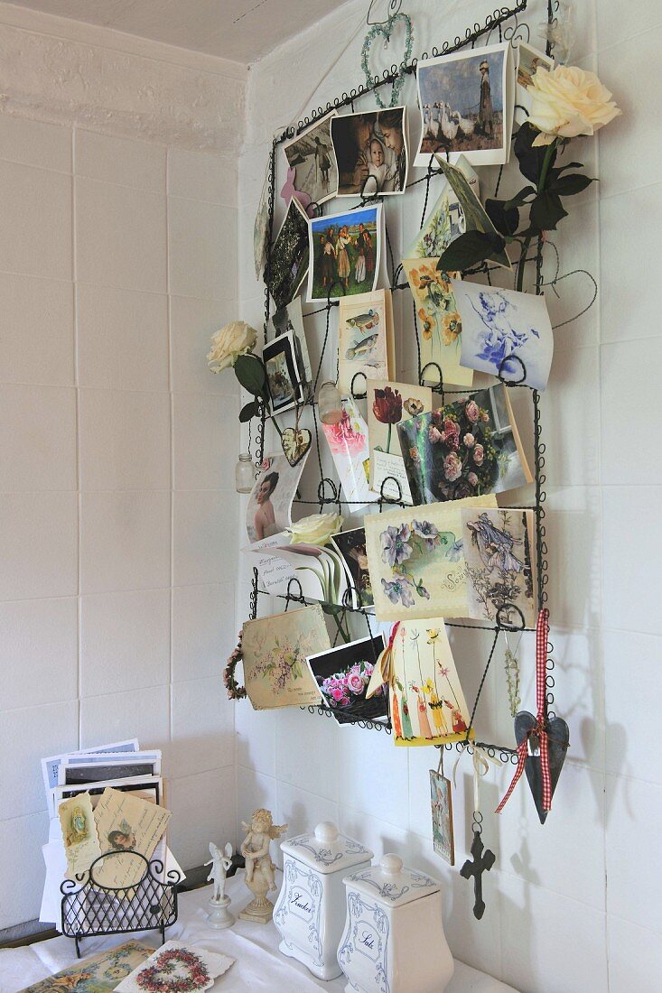 Metal rack of postcards hanging on a white wooden wall
