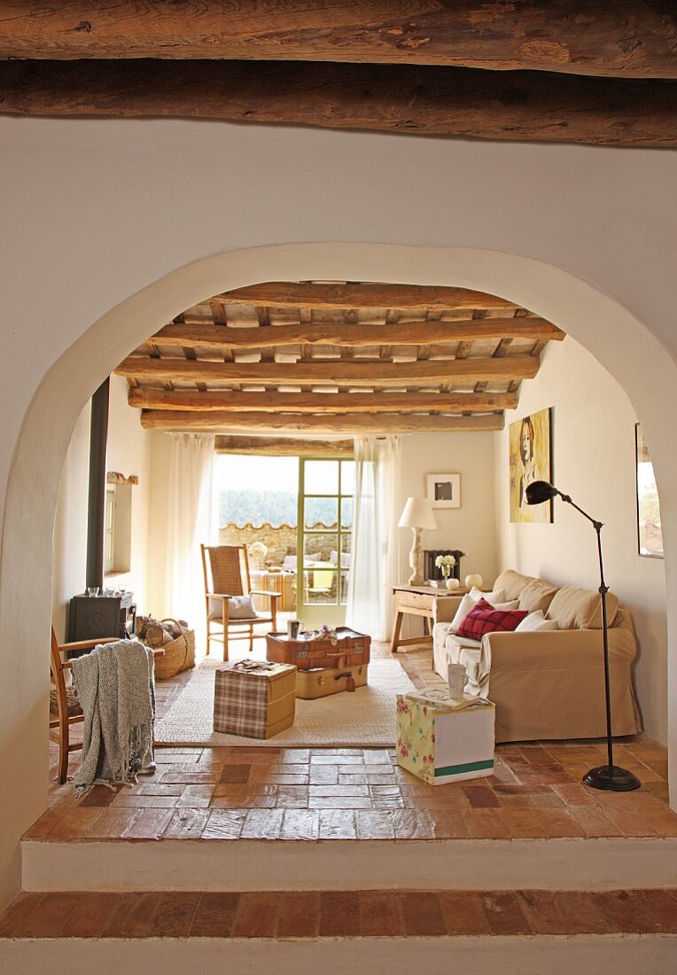 Mediterraner Wohnraum mit Holzdecke und angrenzender Terrasse im renoviertem, spanischem Landhaus