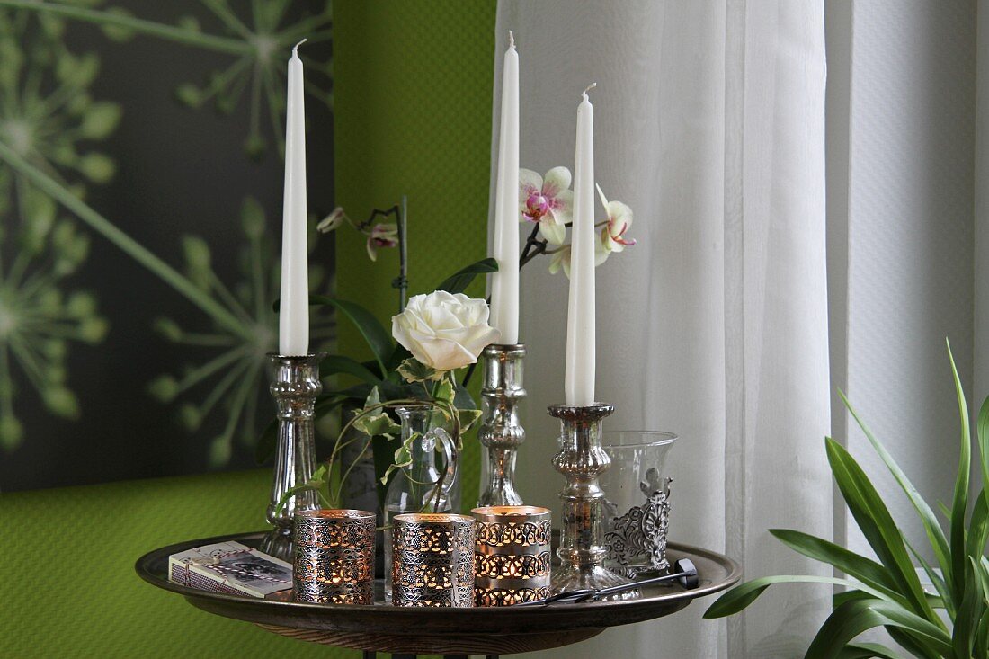 Silver candlesticks and tea light holders on tray