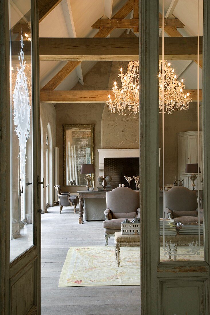 Converted old mill - view through open door into elegant interior with reupholstered Rococo armchairs and chandelier