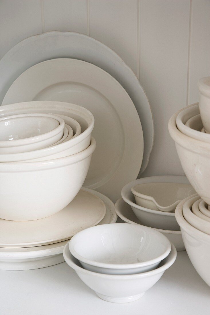 Assorted white dishes stacked in a cupboard