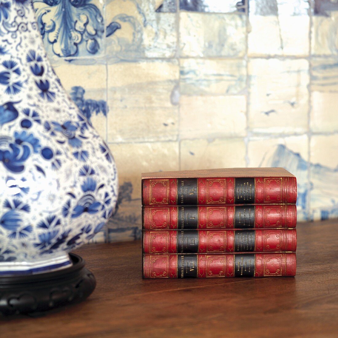 Antike Bücher auf Tisch neben Tischlampe mit weiss blauem Keramikfuss