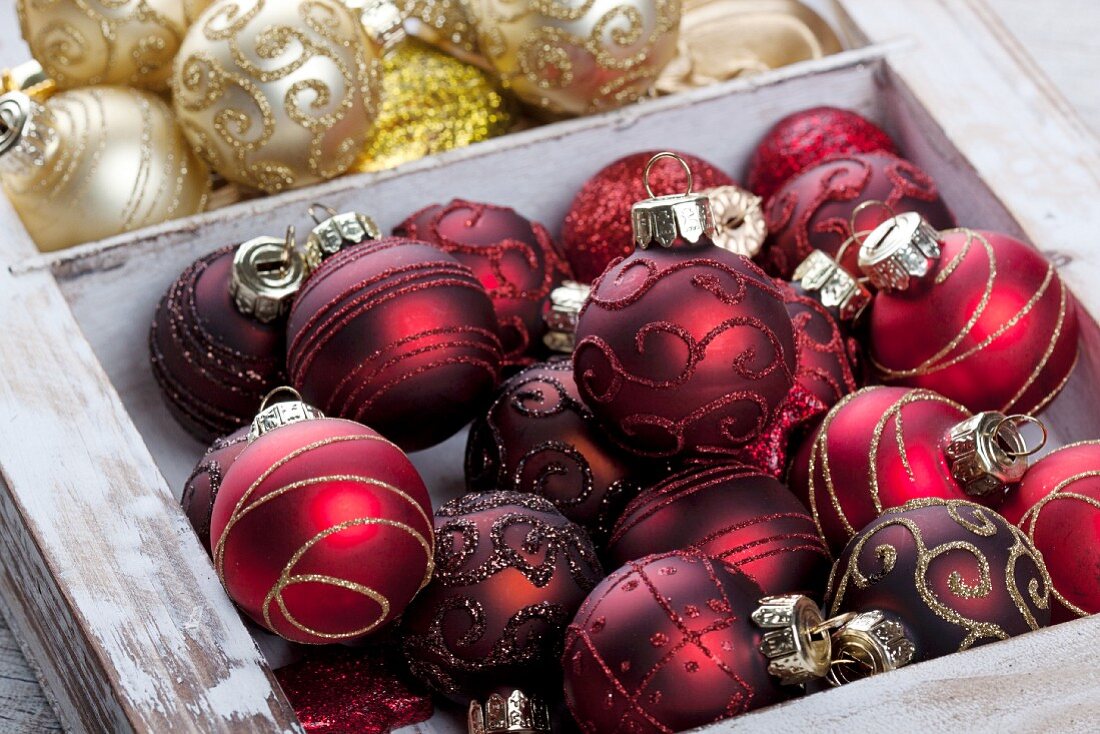 Various Christmas tree baubles in wooden crate
