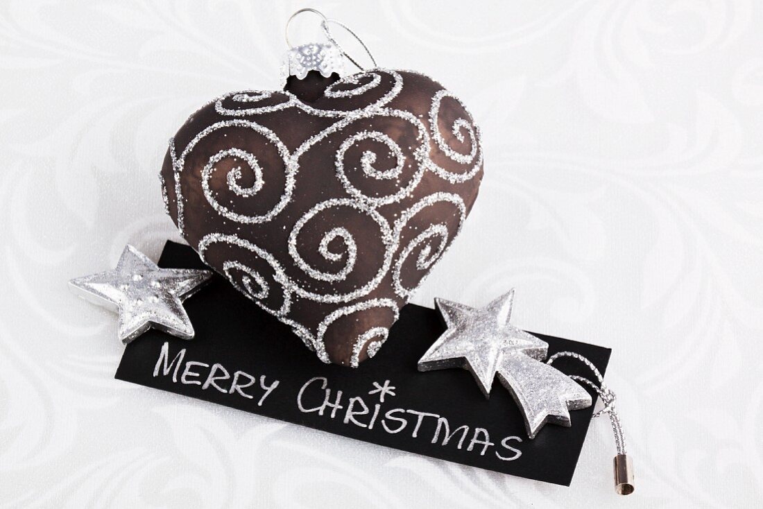 Heart-shaped Christmas tree decoration lying on little card