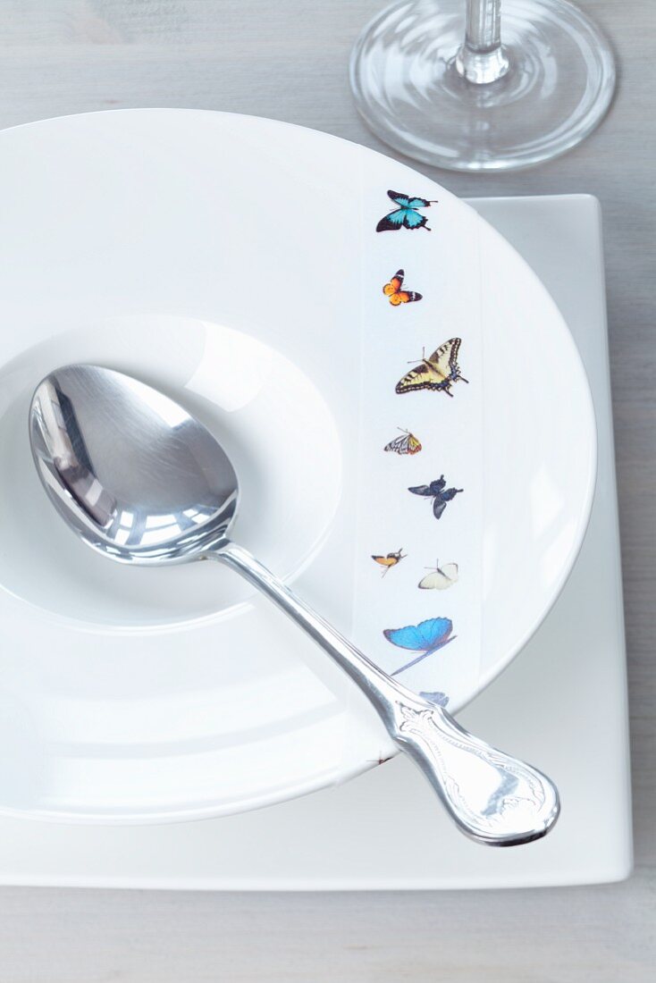 Tape with butterfly motif on deep dish with soup spoon