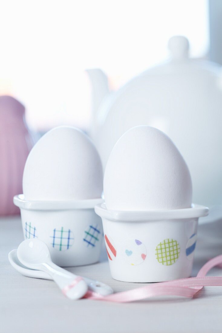 White china egg cups decorated with spots of patterned tape