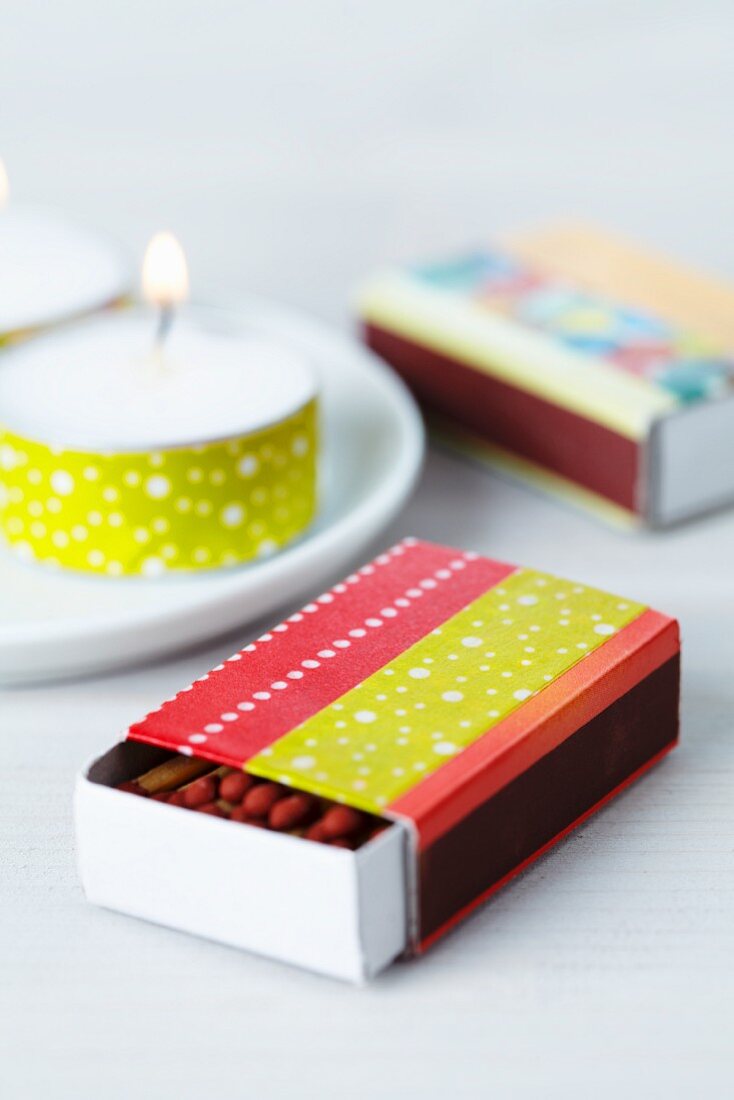 Matchbox covered in red and yellow taps and tealight decorated with yellow tape