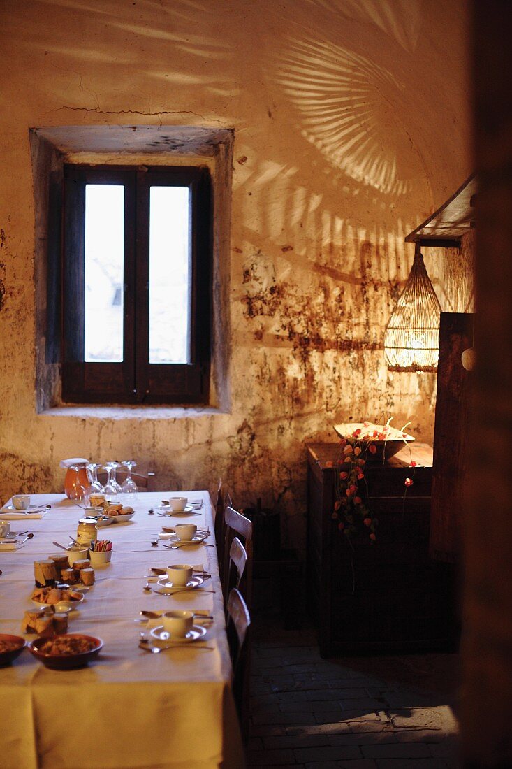 A table laid with small dishes in a rustic dining room with dramatic lighting