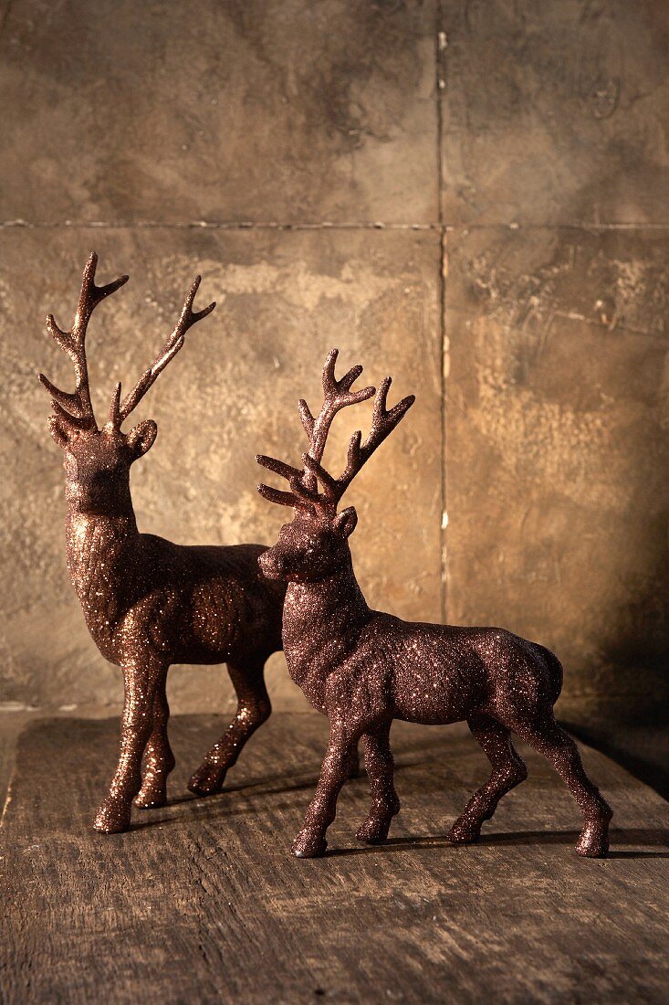 Two stag figurines on a wooden table