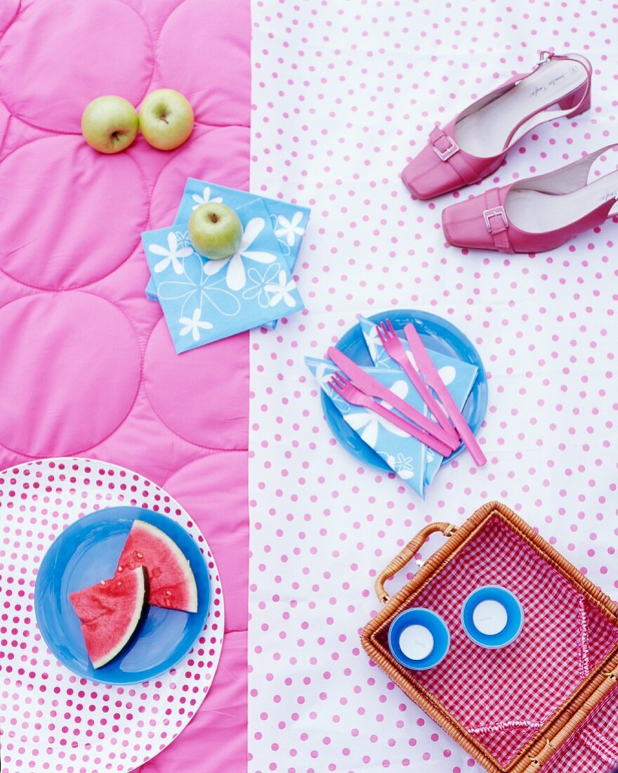 Picknickkorb, Obst, Servietten und Schuhe auf Decke