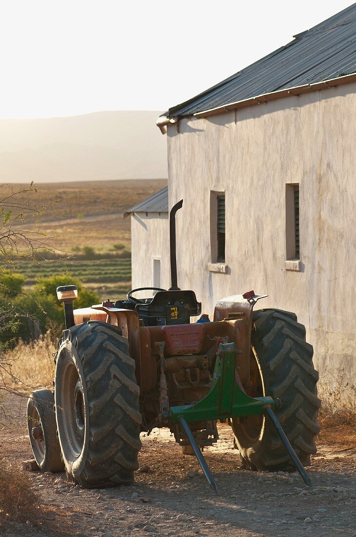 Tractor next to simple farmhouse