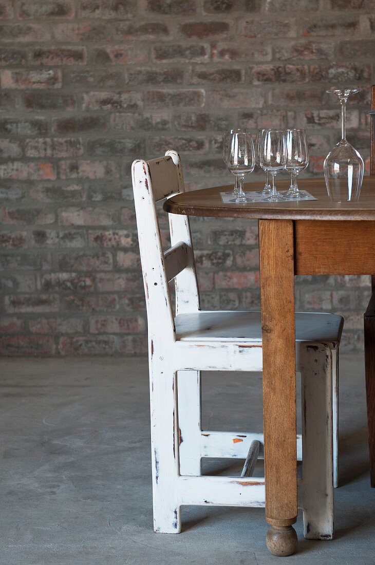 Weingläser auf Holztisch und rustikaler Stuhl