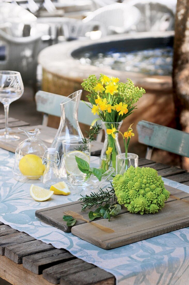 Table set with table runner, bouquet of flowers, Romanesco broccoli and lemons